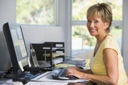 A woman is sitting at a desk in front of a computer.