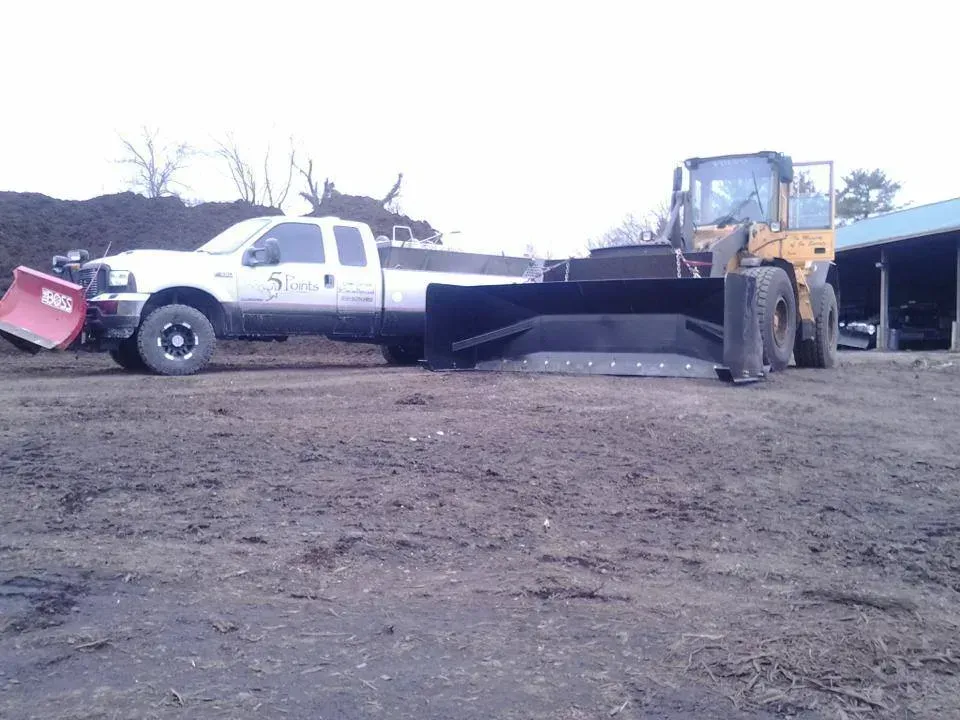 A white truck with a snow plow attached to it